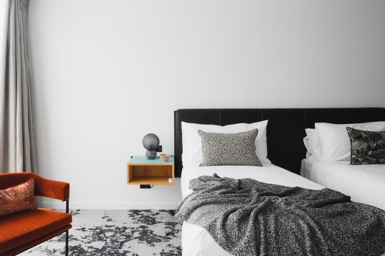 Ebb-ダニーデン エクステリア 写真 A bedroom with a bed, a chair and a nightstand
